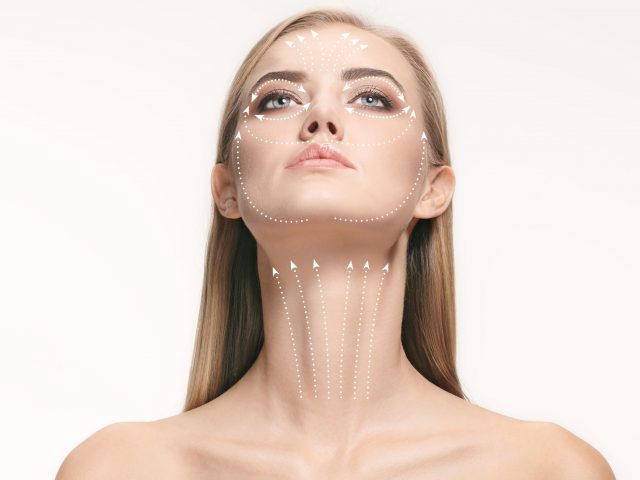 Close-up portrait of young, beautiful and healthy woman with arrows on her face. The spa, surgery, face lifting and skin care concept