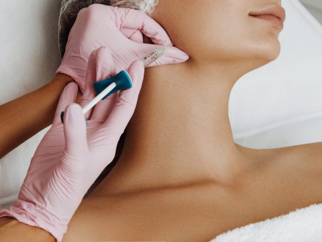 Young woman getting face filler injection