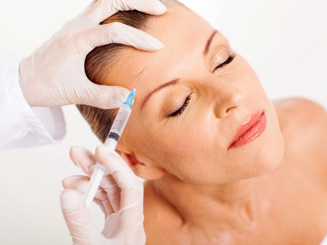 doctor giving face lifting injection on mature woman